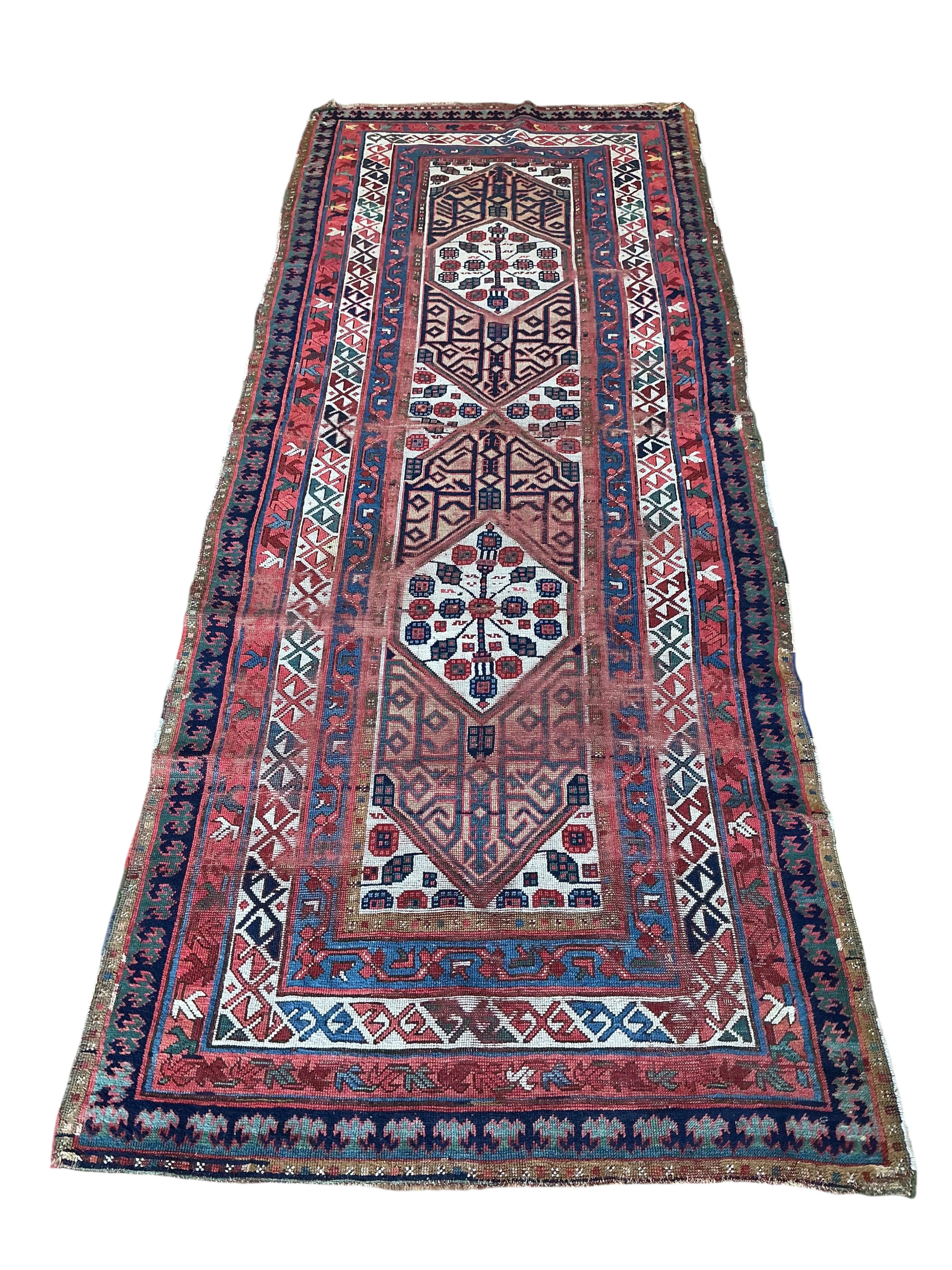 An antique Caucasian red ground runner, 260 x 102cm